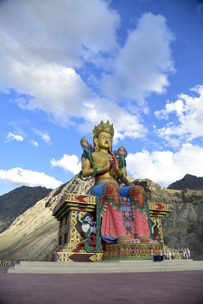 a statue of a buddha sitting on top of a mountain